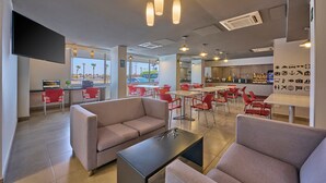 Un interior moderno con zonas de estar, un bar y vistas al exterior.