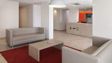 Un lobby moderno con un sofá, una mesa de centro y un mostrador de recepción.