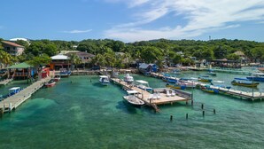 A marina with boats docked, a pier, and buildings in the background.