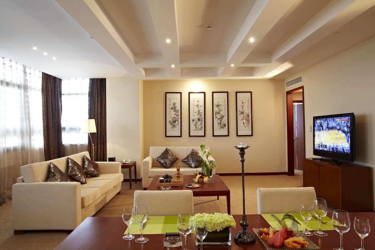 Deluxe Suite | Living area | 29-inch flat-screen TV with cable channels, TV