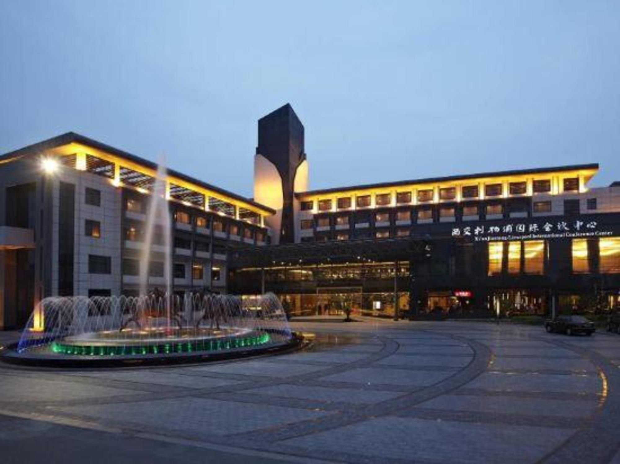 A hotel with a central fountain, a modern building with a tall tower, and a sign indicating it is a conference center.