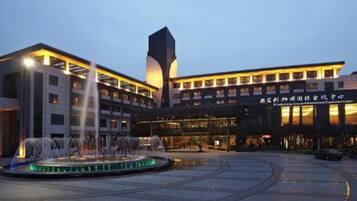 A hotel with a central fountain, a modern building with a tall tower, and a sign indicating it is a conference center.