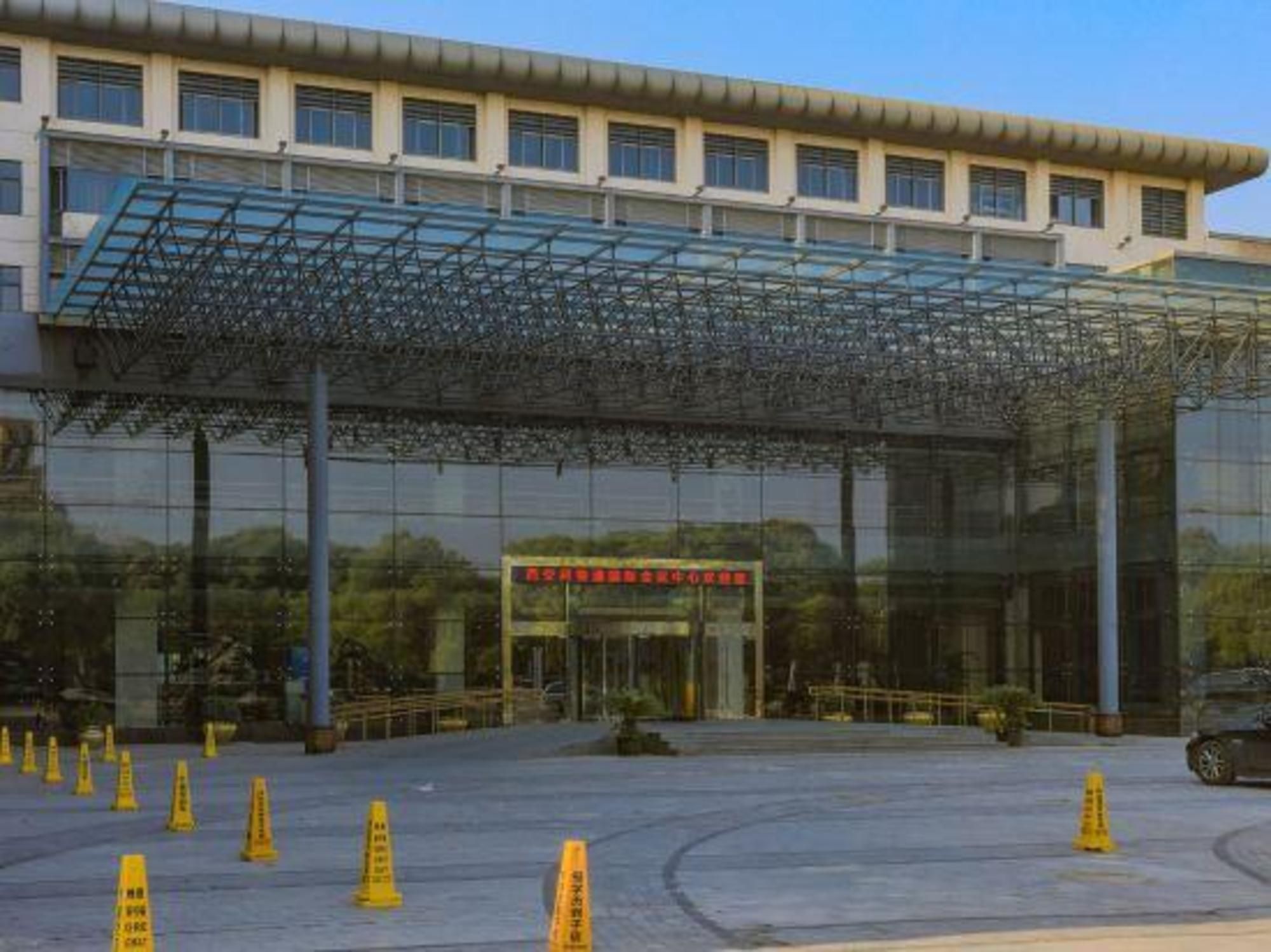 Un edificio con facciata in vetro e ingresso coperto.