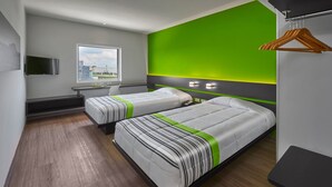 Een moderne hotelkamer met twee bedden, een bureau en een televisie.