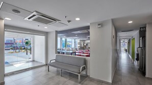Een modern interieur met een bank, een glazen deur naar buiten en een zichtbare keukenhoek.