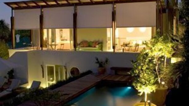 A modern two-story house with a swimming pool, wooden deck, and outdoor seating area. - Four Rosmead (Cape Town)