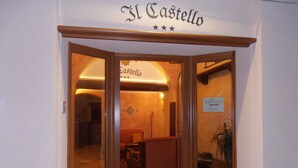 Entrada de un hotel con un cartel que dice "Il Castello".