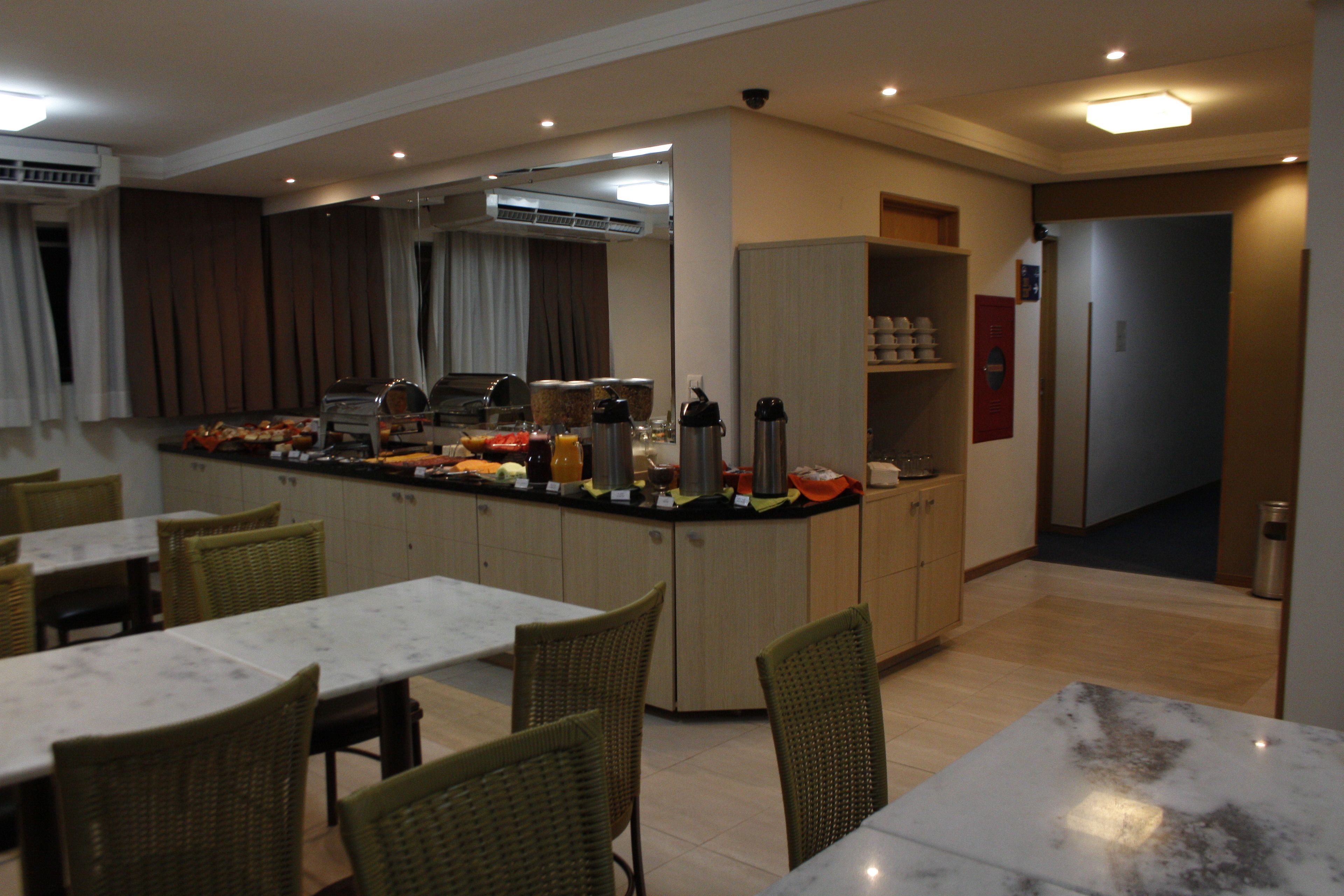 Une cuisine moderne dotée d’un îlot central, d’un coin repas avec tables et chaises, et d’une salle à manger séparée.