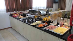 A buffet setup with various food items and utensils. - Barigui Park Hotel (Curitiba)