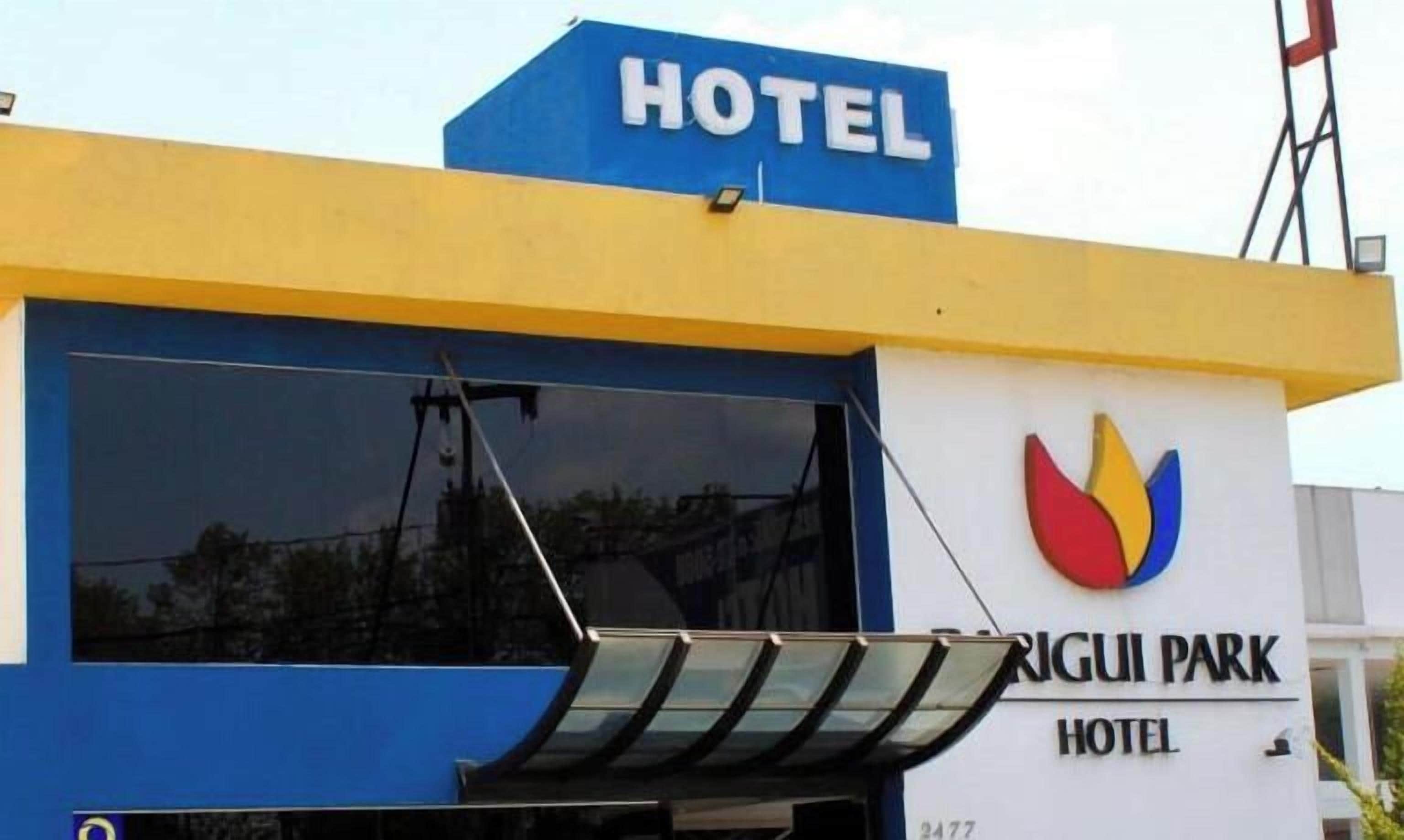 A hotel with a blue and yellow facade, a large window, and a logo with a flame design.