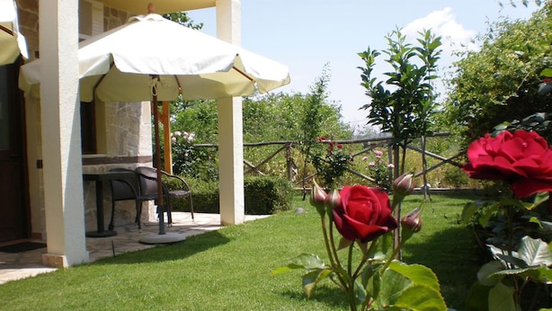 Un patio con mobiliario exterior y un paraguas blanco.