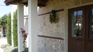 Un edificio de piedra con una puerta de madera y una planta en maceta al lado.