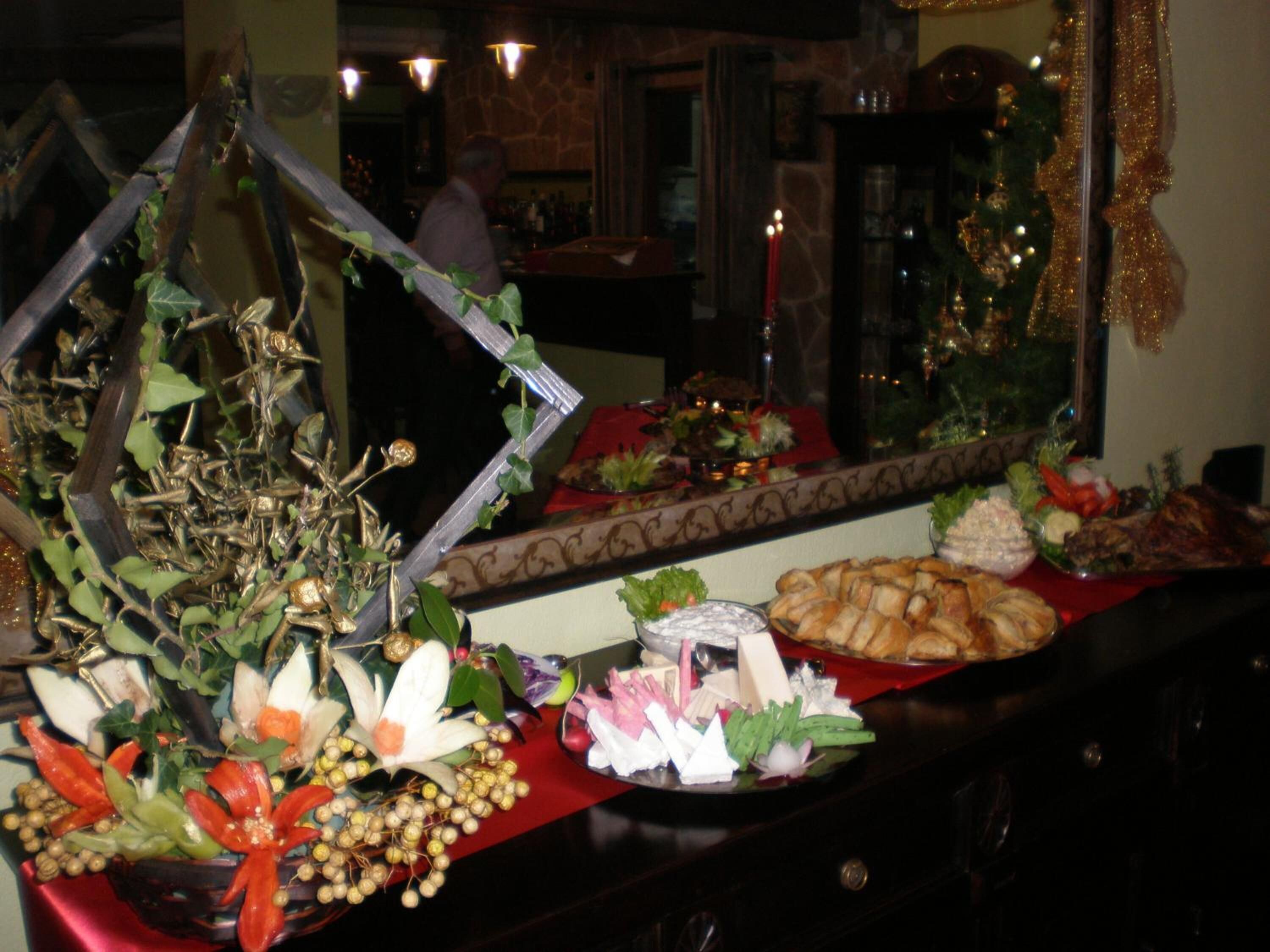 A buffet table with various food items and a decorative centerpiece.