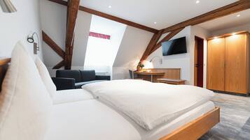Una camera da letto con un letto, una scrivania, una TV e un armadio.