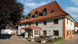 A building with a tiled roof, multiple windows, and a sign reading 'Zum Rössle'.
