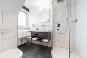 A modern bathroom with a shower, toilet, and vanity. - Hotel Gasthof Zum Rössle (Altenstadt)