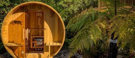 A wooden spherical structure with a door, a small seating area, and a shelf inside.