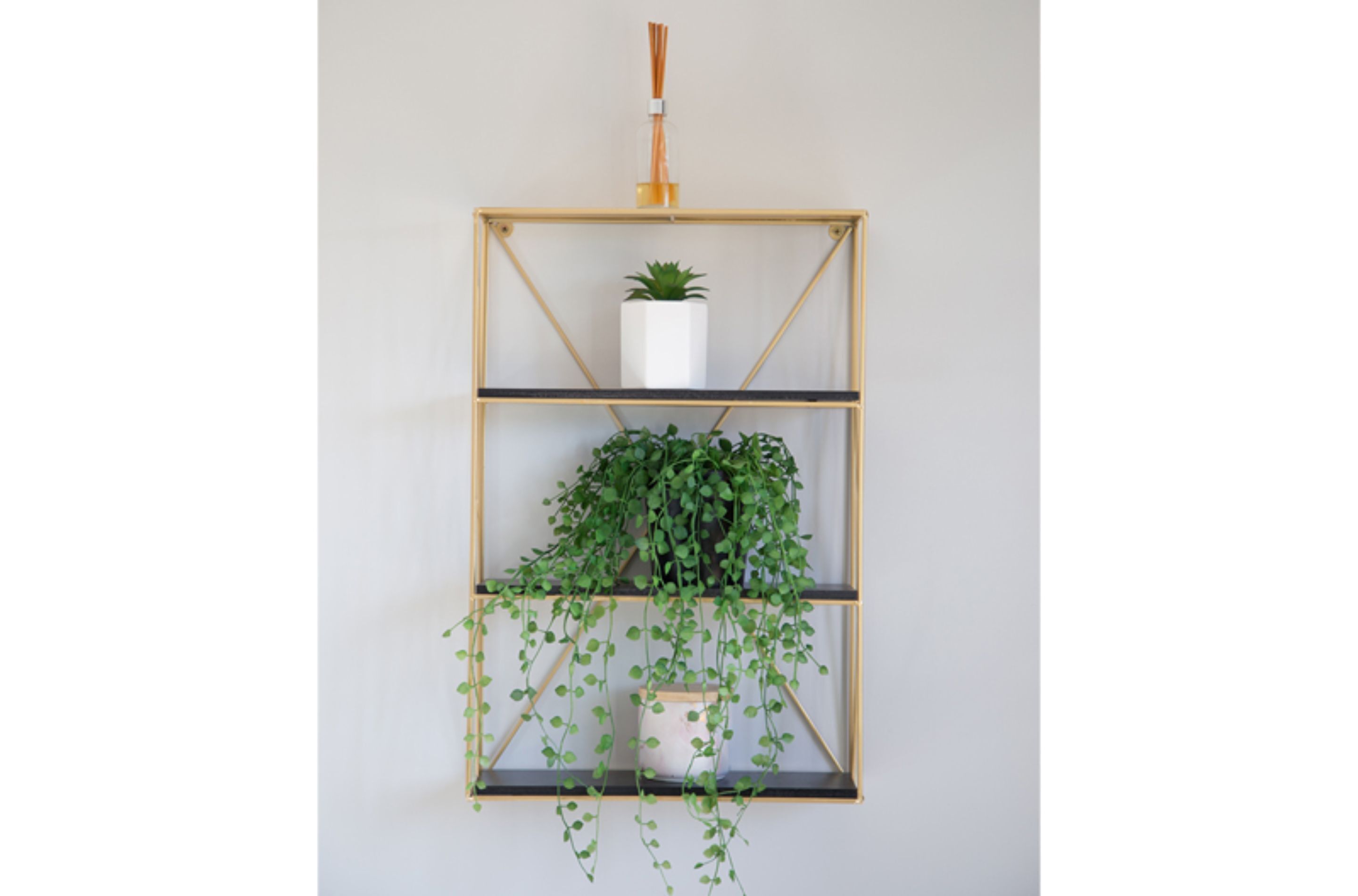 Estante de madera fijado a la pared con tres niveles, cada uno con una planta en maceta.
