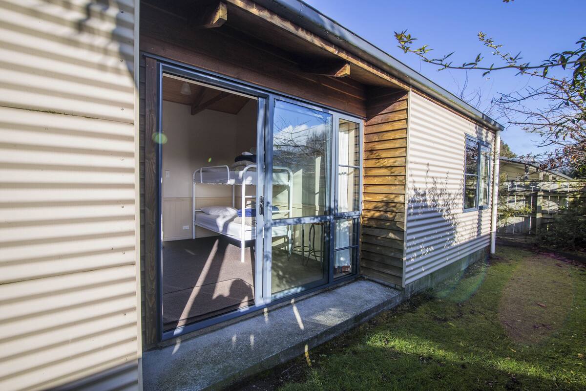 A mobile home with a sliding glass door entrance, a small porch area, and a visible kitchen space.
