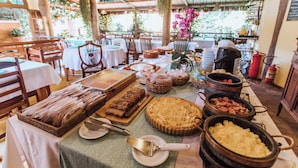 Montaje de bufé con diversos platos, incluyendo pasteles y cazuelas, dispuestos en mesas.