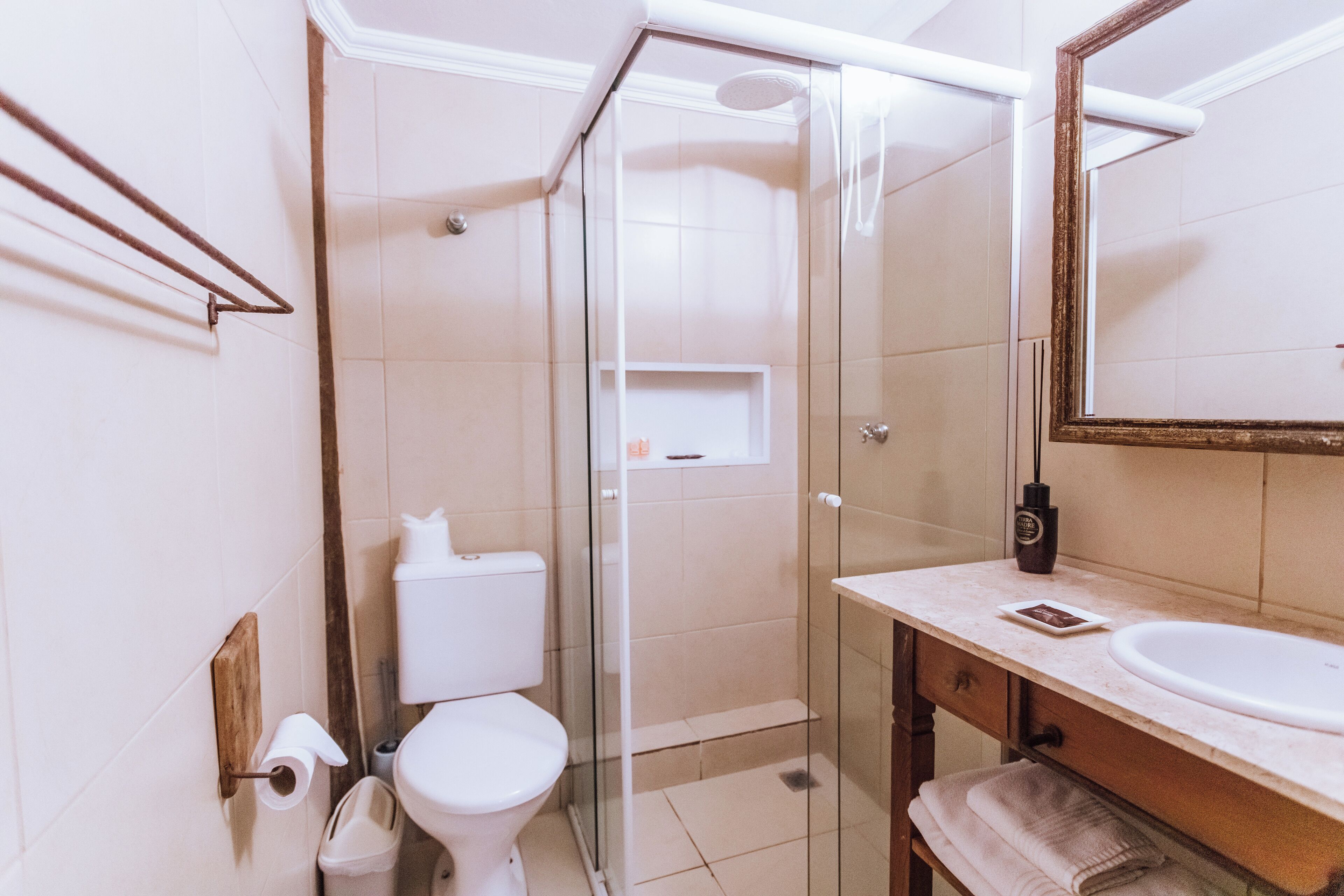 Ein Badezimmer mit Duschkabine, Toilette, Waschbecken und Spiegel.
