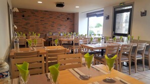 Un restaurante con paredes de ladrillo, mesas y sillas de madera.
