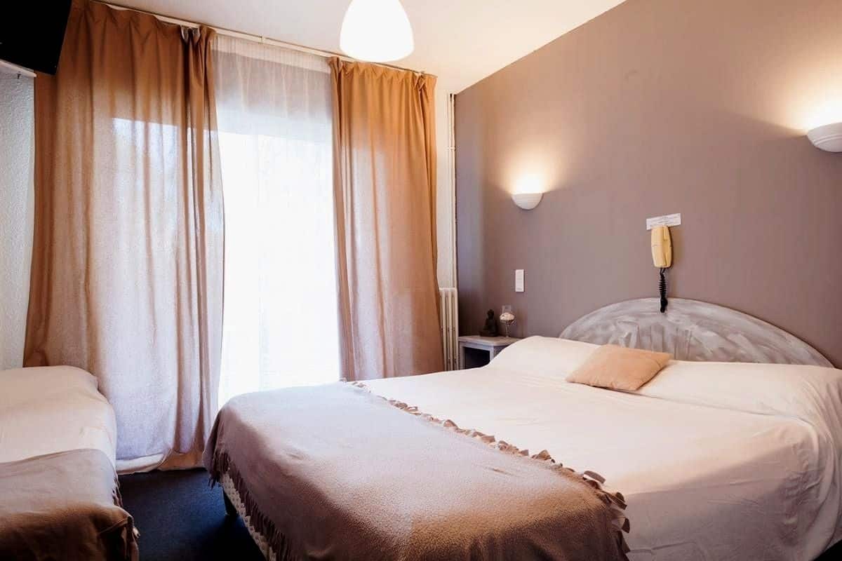 Une chambre d’hôtel avec un grand lit, une table de chevet, une lampe et un téléphone.