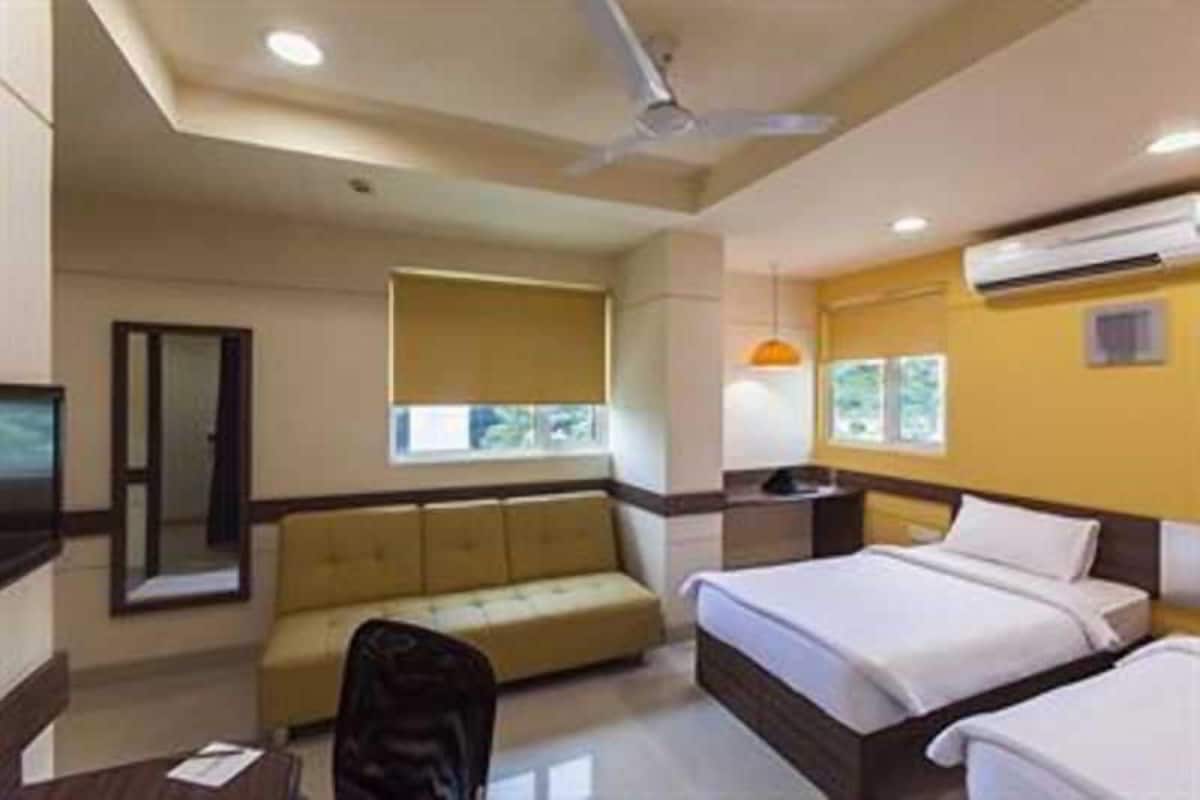 Una habitación de hotel con una cama, un sofá, un escritorio y una silla.