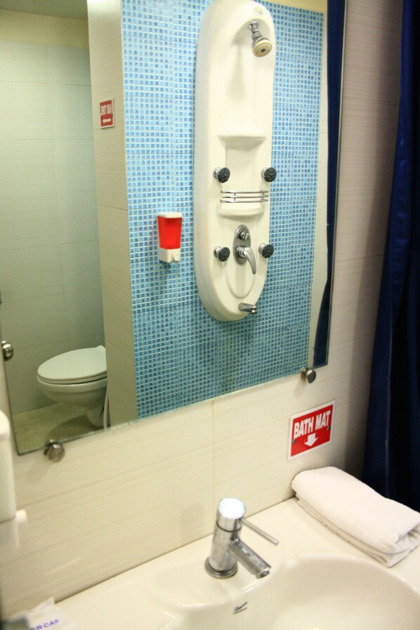 A bathroom with a white sink, a mirror, a blue tiled wall, and a white toilet.