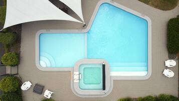 Una piscina al aire libre, tumbonas