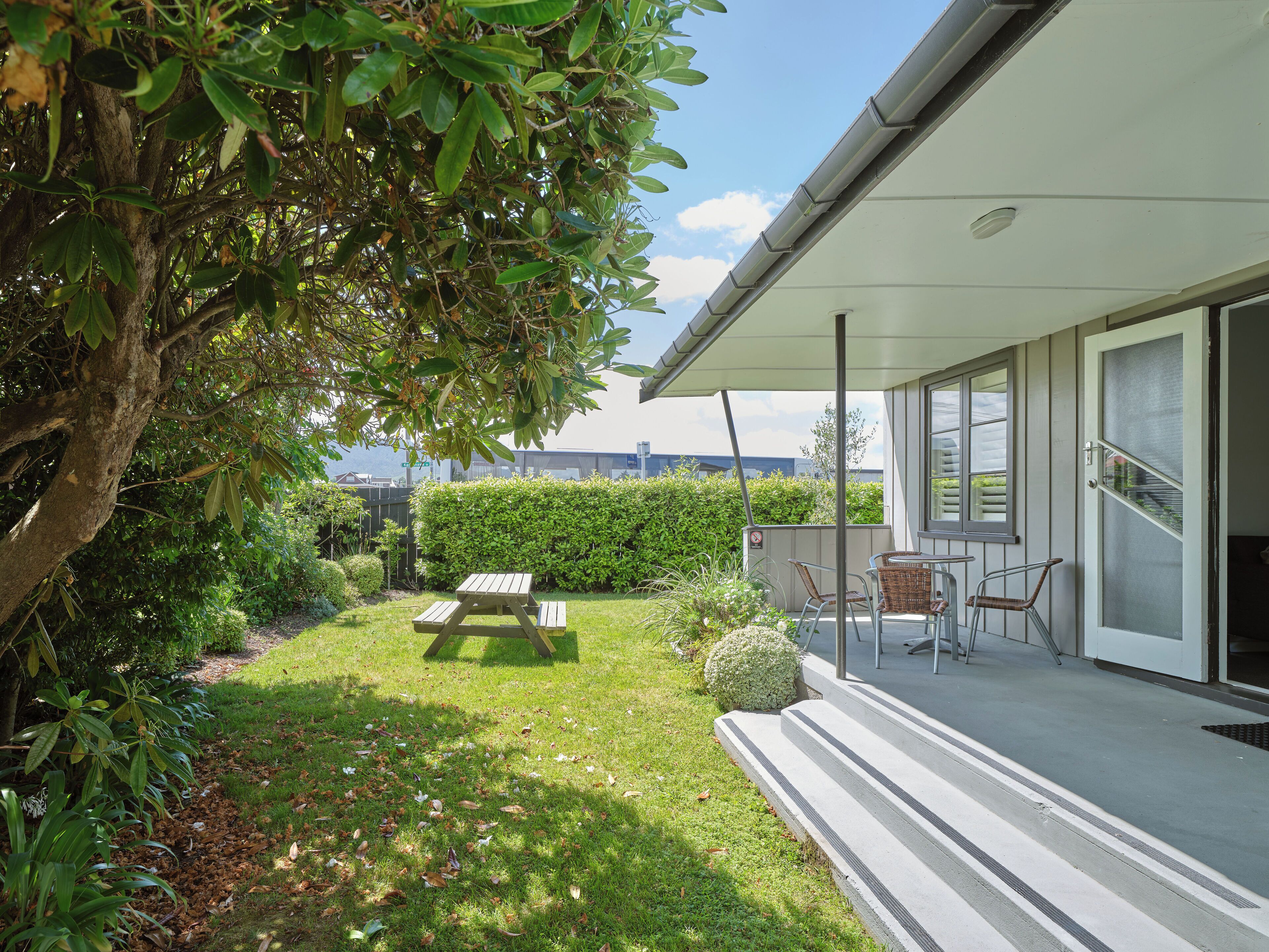 A modern house with a covered patio, a picnic table, and a view of the city.