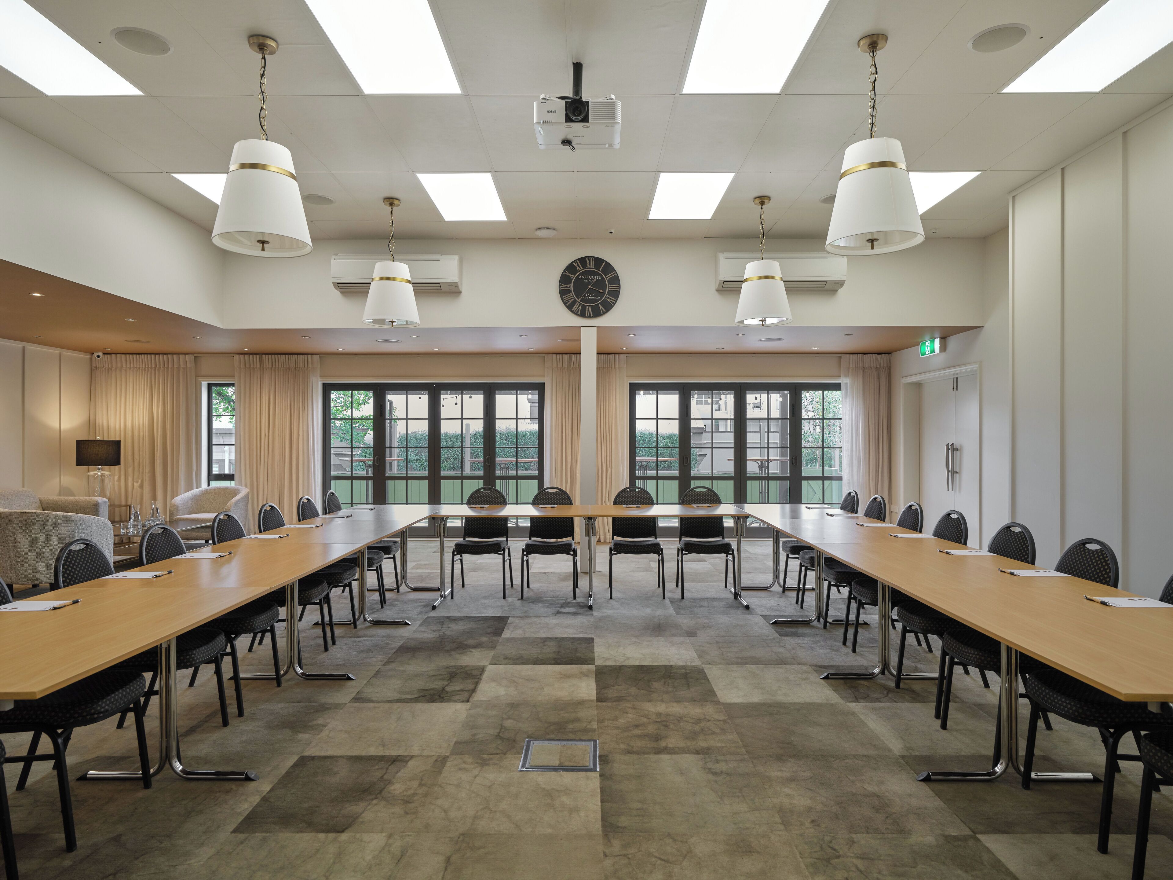 A conference room with a long table, chairs, and a clock on the wall.