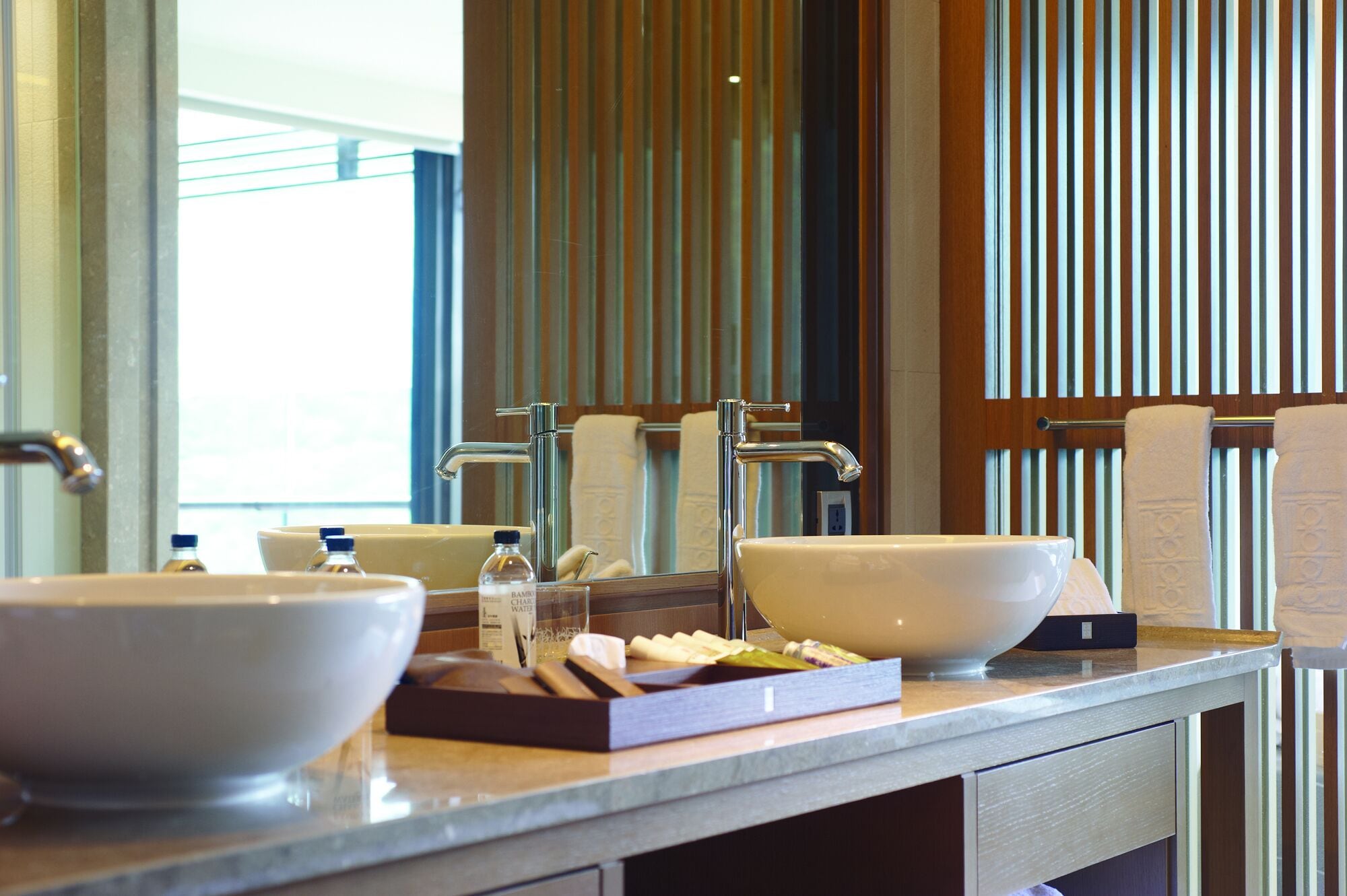 A bathroom with two large white sinks, a mirror, and a towel rack.