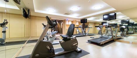 A gym with multiple treadmills, stationary bikes, and exercise equipment.
