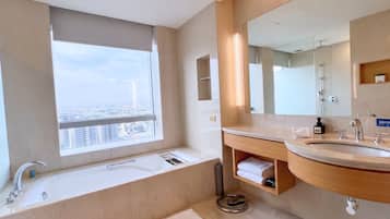 Un bagno moderno con una vasca, un lavandino e uno specchio grande.
