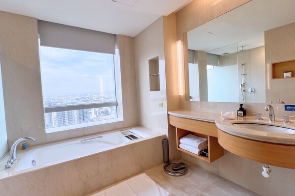 A modern bathroom with a bathtub, a sink, and a large mirror. - Windsor Hotel Taichung (Taichung)