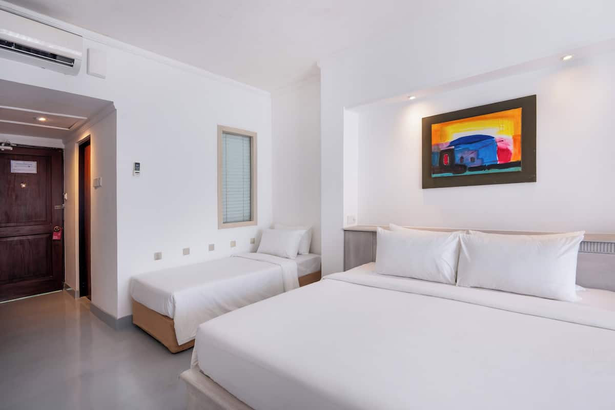 Ein Hotelzimmer mit zwei Einzelbetten, einem großen Bett, einem Bild an der Wand und einer Tür mit einem Schild.