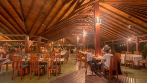 An indoor dining area with wooden tables and chairs, under a high wooden ceiling with exposed beams. - The Palms (Beruwala)