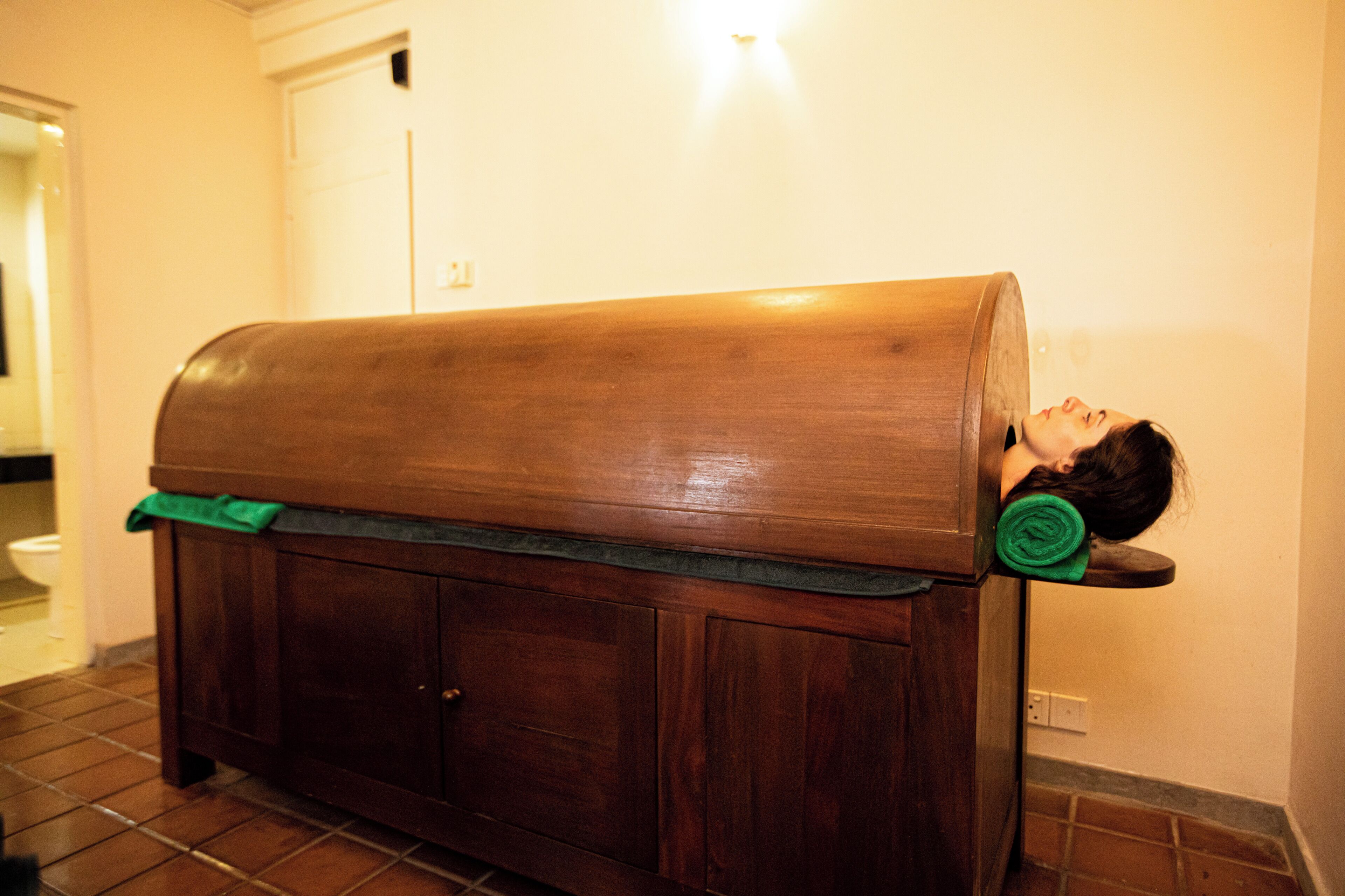 A wooden bench with a person lying on it.