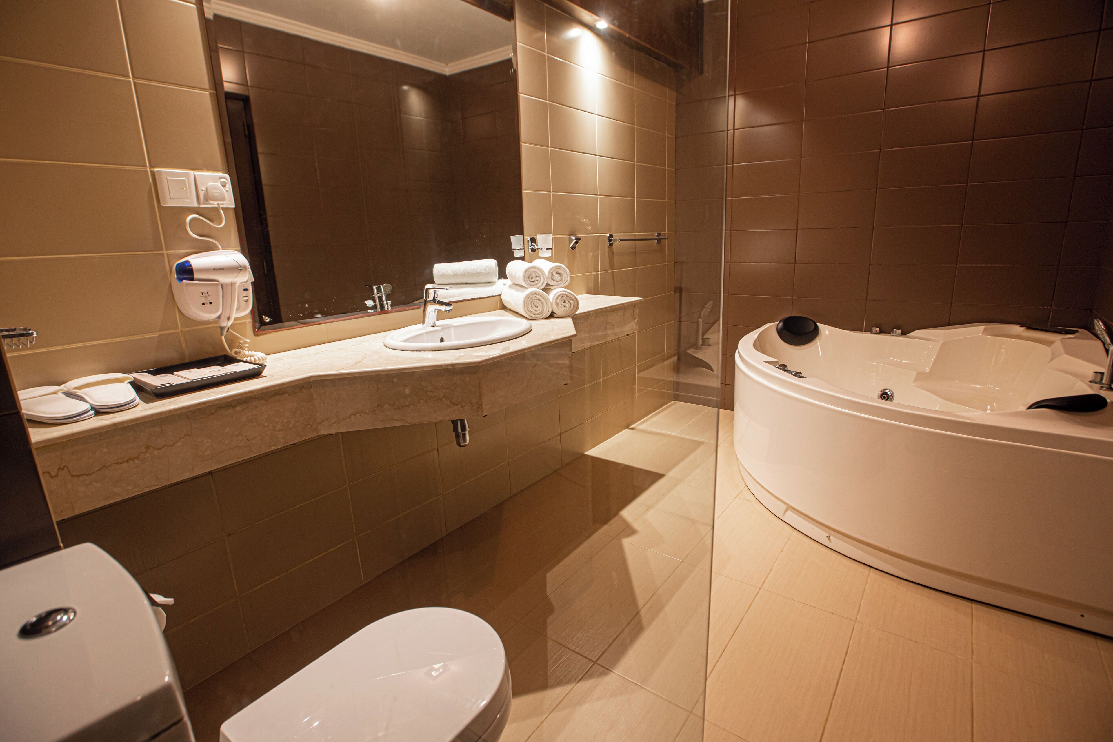 A modern bathroom with a bathtub, toilet, and sink.