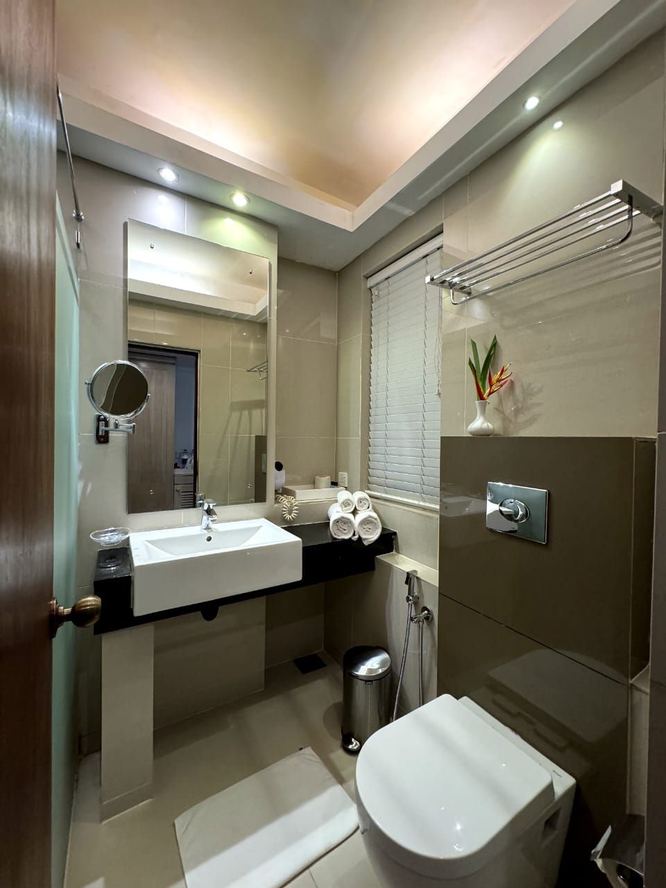 Ein modernes Badezimmer mit Waschbecken, Spiegel und Toilette.