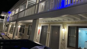 Eine mehrstöckige Tiefgarage mit überdachtem Gang und mehreren Eingängen, vermutlich zu Hotelzimmern.