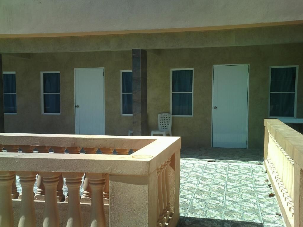 A building with a tiled patio, multiple doors, and a white chair.