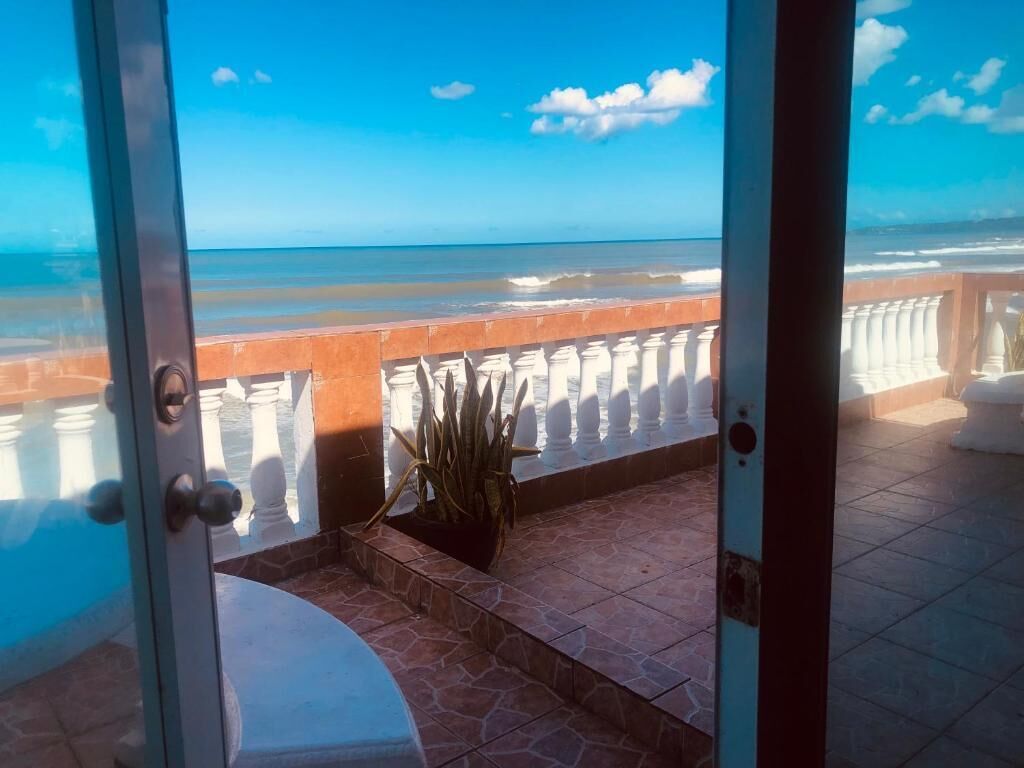 Blick vom Balkon auf den Ozean, mit Fliesenboden und einer Topfpflanze.