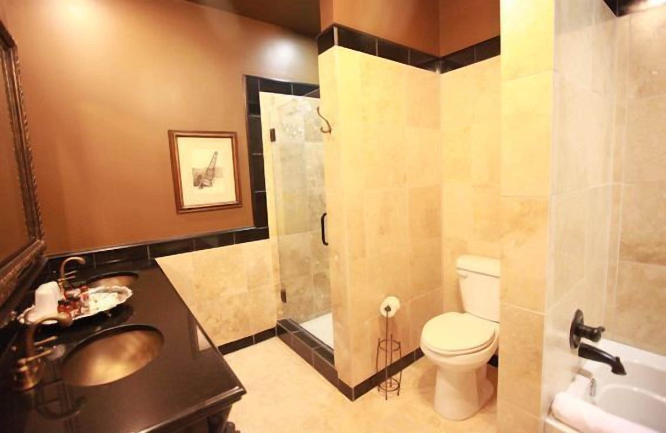 Un baño con lavamanos, inodoro y zona de ducha.
