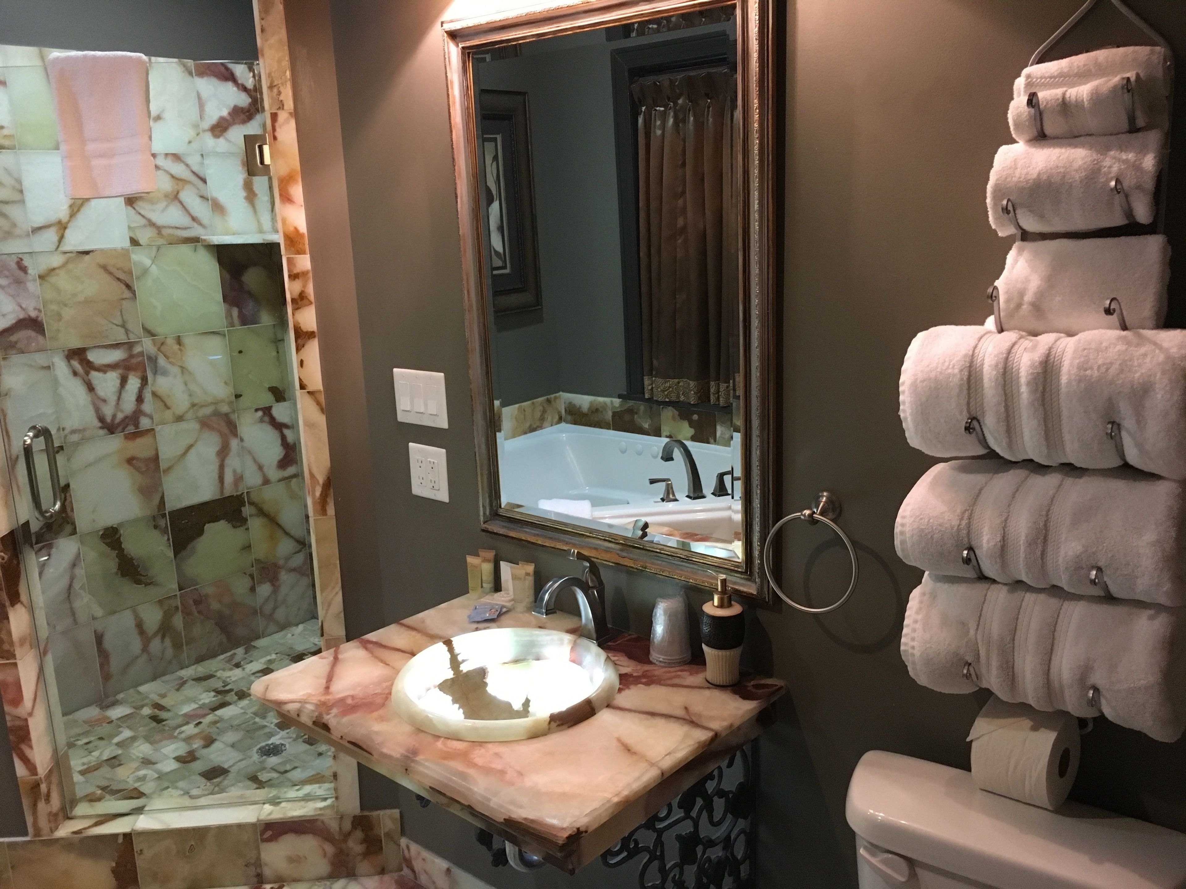 Une salle de bain avec un lavabo en marbre, un miroir, un porte-serviettes et un espace douche.