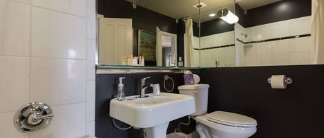Un baño moderno con lavamanos, inodoro y bañera blancos.