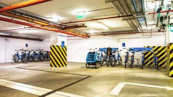 Eine mehrstöckige Parkgarage mit abgestellten Fahrrädern und Rollern.
