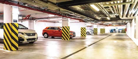 A multi-level parking garage with concrete floors and yellow-striped pillars.