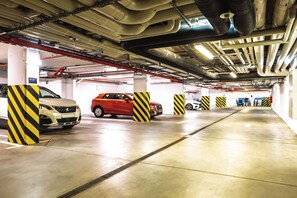 A multi-level parking garage with concrete floors and yellow-striped pillars.